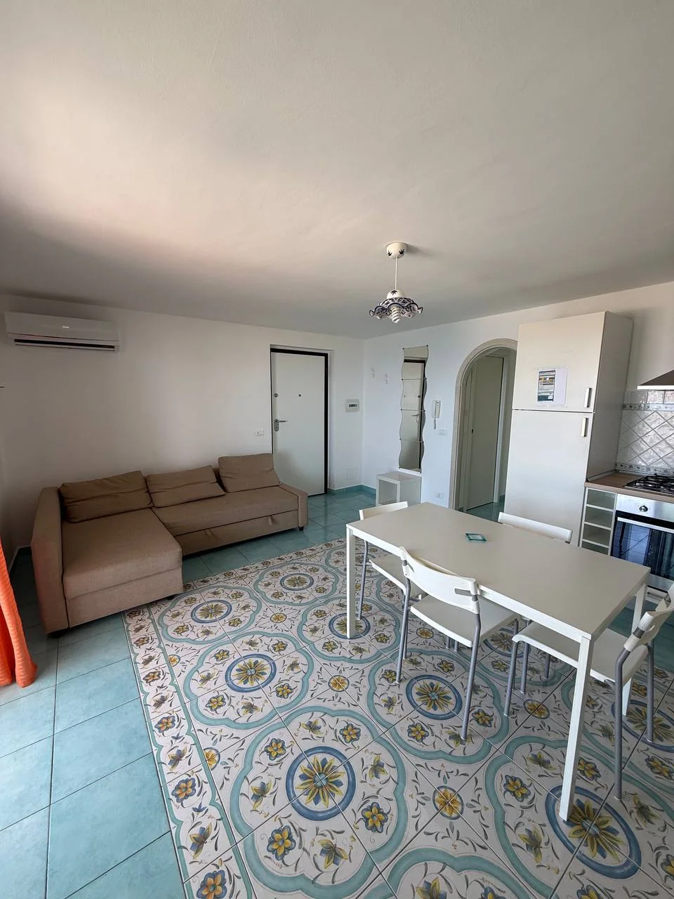 Soggiorno di Arcobaleno con cucina, tavolo bianco e divano beige