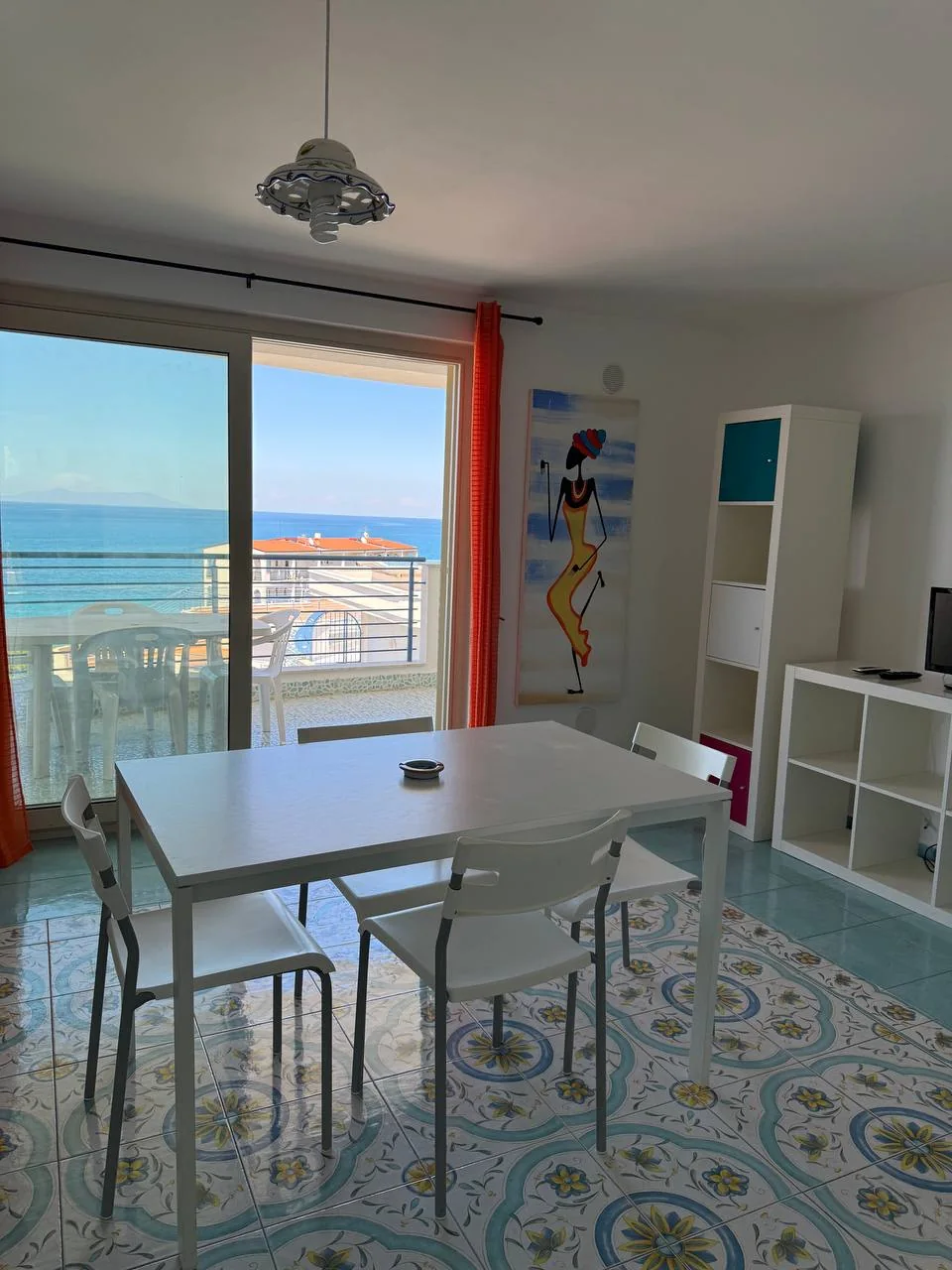 Zona pranzo di Arcobaleno con pavimento in maiolica e vista mare